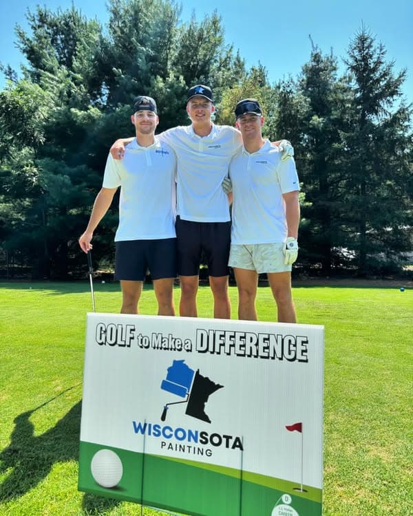 Three golfers pose in front of a sign reading "Golf to Make a Difference" at a charity event.