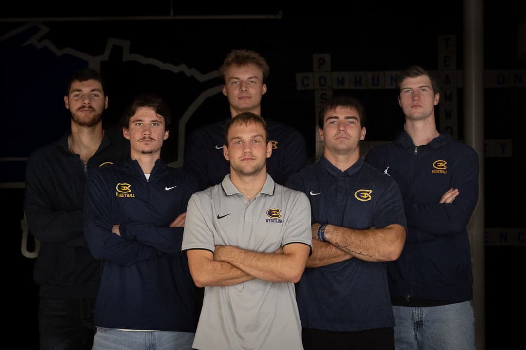 Group of six male volleyball players posing confidently in athletic apparel.