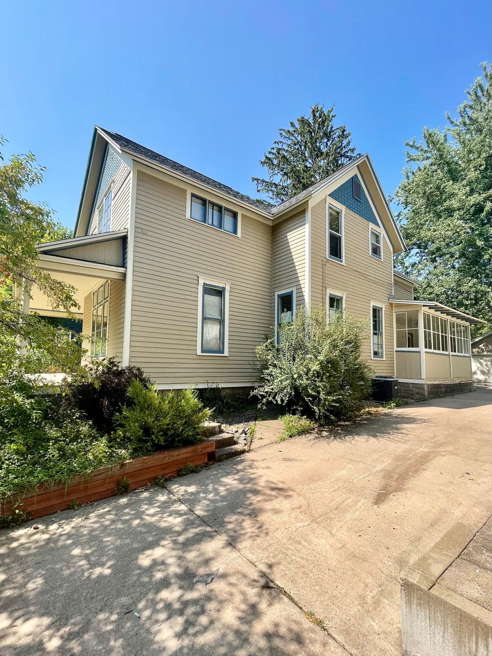 Victorian-style house with lush landscaping and clear blue sky. Perfect for home buyers.